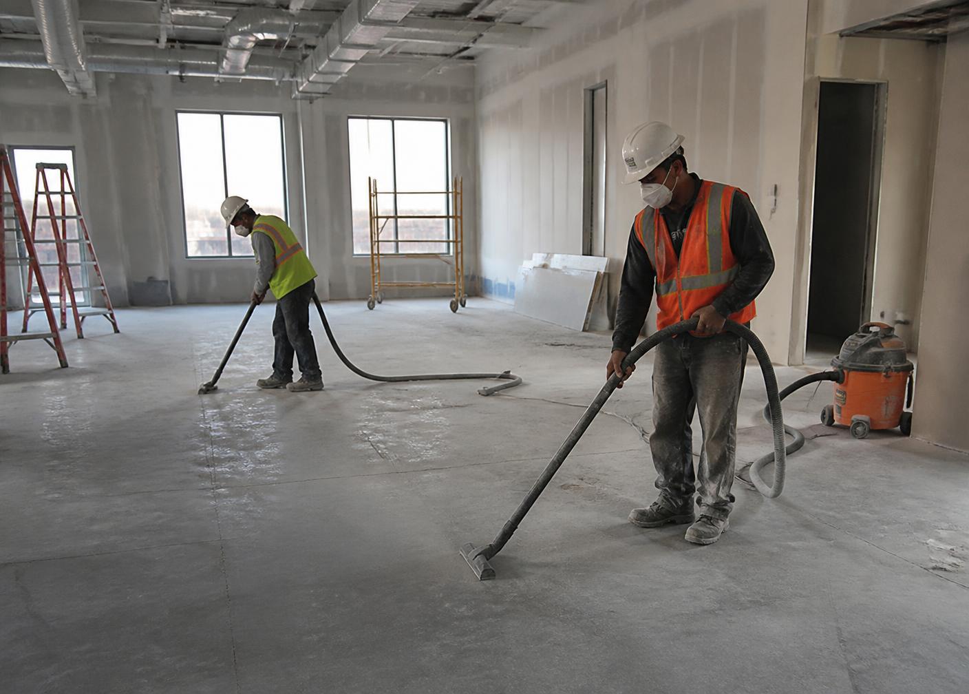 Post-construction cleaning crew removing drywall dust from a newly built space in Madison, WI